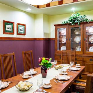 A beautifully arranged dining room with a wooden table set for a meal, complete with a china cabinet and decorative elements.