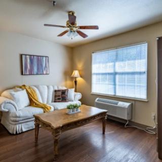 A cozy living room with a sofa, coffee table, and large window.