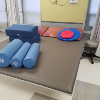 A physical therapy room with foam rollers, yoga blocks, and exercise mats.