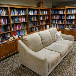A cozy reading nook featuring a comfortable sofa surrounded by shelves full of books.