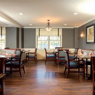 An elegant dining room with neatly arranged tables and chairs, featuring tasteful decor and soft lighting.