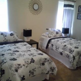 A cozy bedroom featuring twin beds with floral bedding and stylish decor.