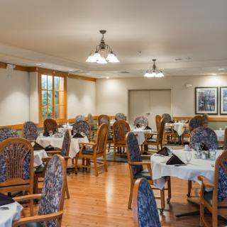 A cozy dining area featuring elegant tables and chairs set for a meal.