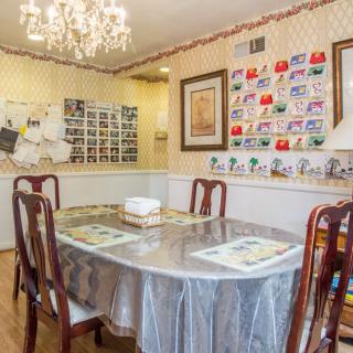 A cozy dining room with a chandelier and wall decorations.