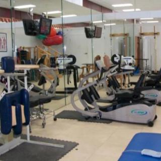 A gym with various exercise equipment, including bikes and machines.