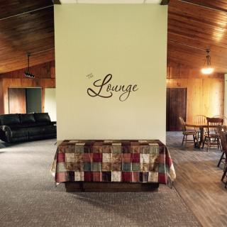 A cozy lounge area with wooden ceilings and a comfortable seating arrangement.