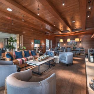 A modern and cozy living room with stylish furniture and a wooden ceiling.