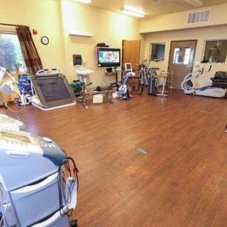 A spacious rehabilitation room equipped with various medical and exercise machines.