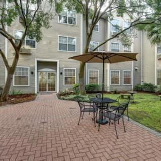 A peaceful courtyard with patio furniture and an umbrella surrounded by apartment buildings.