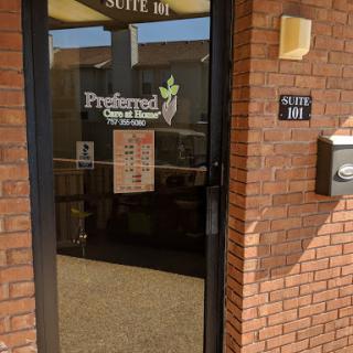 Entrance to a business office, featuring a glass door and brick facade.