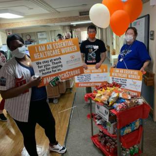 Healthcare workers celebrate with snacks and balloons, promoting community support.