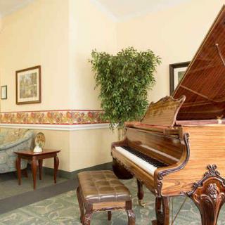 A beautifully decorated lobby featuring a grand piano and elegant furnishings.