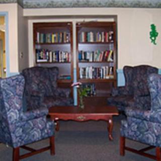 A cozy reading area with armchairs and a bookshelf.