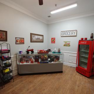 A vintage-style grocery store interior with retro decor and a red refrigerator.