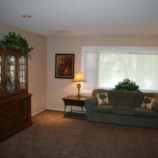 A cozy living room with a sofa, cabinet, lamp, and decorative elements.