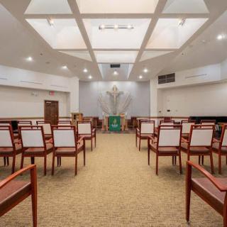 A spacious and well-lit worship room with neatly arranged chairs.