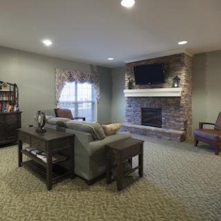 A cozy living room featuring a stone fireplace and comfortable seating.