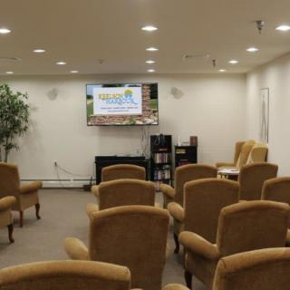 A conference room with arranged seating facing a television for presentations.