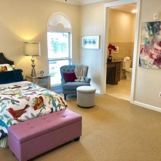 A cozy bedroom with vibrant decor and an attached bathroom.