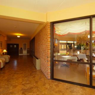A welcoming hallway with a seating area and large glass windows.