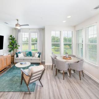 A modern, bright living room and dining area with large windows and stylish decor.