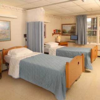 A well-organized hospital room with two beds and medical equipment.