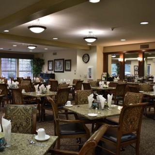 An empty dining room with neatly arranged tables and chairs.