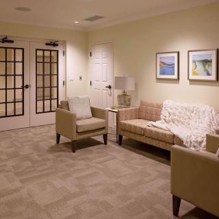 A cozy waiting room with comfortable seating and wall art.