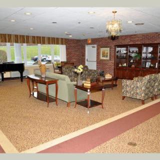 A cozy living room with a piano, comfortable seating, and elegant decor.