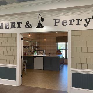 A cozy cafe entrance with a welcoming sign above the doorway.