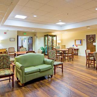 A warmly lit lounge area with comfortable seating and wooden flooring.