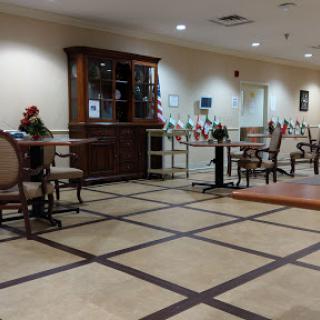 A view of a spacious lobby area featuring wooden furniture, decorative touches, and tiled flooring.
