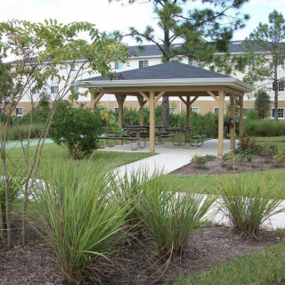 A peaceful garden gazebo surrounded by lush greenery and a winding pathway.