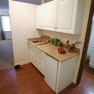 A small kitchen area with white cabinets, a countertop, and decorative items.