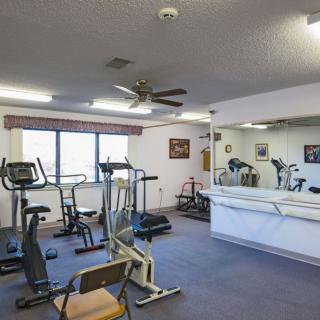A small indoor gym with various exercise equipment and a large mirror.