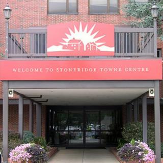 Entrance to a building with a welcome sign and decorative flowers.