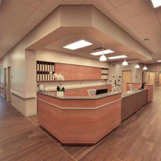 A modern reception area with a wooden desk and organized shelving.