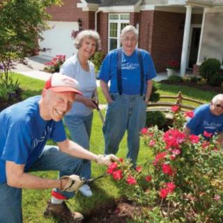 A group of seniors enjoying gardening together in a residential neighborhood.