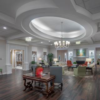 A modern lobby with elegant furnishings and a central chandelier.