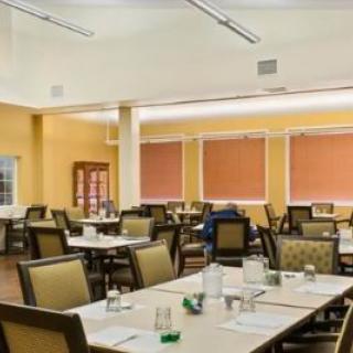 An empty dining room with tables and chairs arranged neatly.
