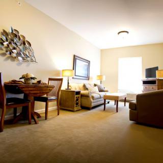 A cozy living room featuring a comfortable sofa, a dining table, and a television.