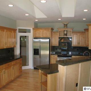 A modern kitchen with wooden cabinets and stainless steel appliances.