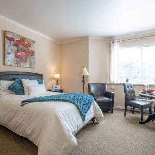 A cozy bedroom with a neatly made bed and stylish decor.