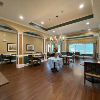 An elegant dining room with wooden floors and chandeliers.