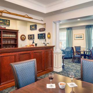 A cozy and traditional bar interior with wooden furnishings and a seating area.