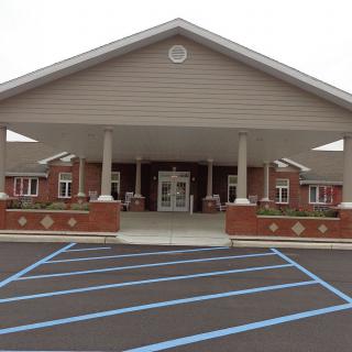 Front view of a building with an entrance and parking area.