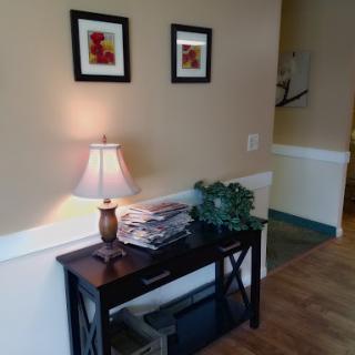 A cozy entryway featuring a small table with decorative items and framed artwork.