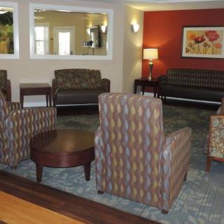 A cozy lobby with multiple seating arrangements, including chairs and a sofa.