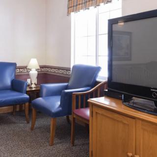 A cozy living room with blue chairs and a television.