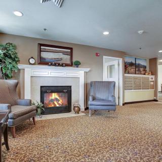 A cozy living room with a fireplace, comfortable chairs, and stylish decor.